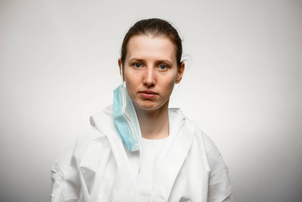 Young woman nurse standing with medical mask removed - Fotó, kép