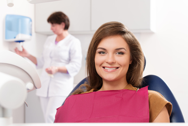 νεαρή γυναίκα μελαχρινή με όμορφο χαμόγελο επισκέπτονται τον οδοντίατρο - Φωτογραφία, εικόνα