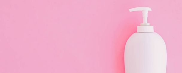 Fles antibacteriële vloeibare zeep en handreiniger op roze achtergrond, hygiëneproduct en gezondheidszorg - Foto, afbeelding