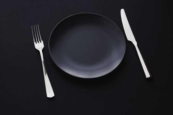Empty plates and silverware on black background, premium tableware for holiday dinner, minimalistic design and diet - Zdjęcie, obraz