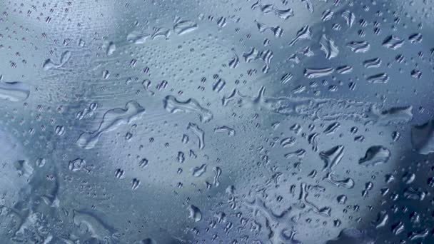 Close-up de gotas de água no vidro, fundo de chuva com gotas de água no vidro, após o dia de chuva dura. fundo luz azul, tristeza humor azul solitário, solidão isolada, emocional, conceito de ciência
 - Filmagem, Vídeo