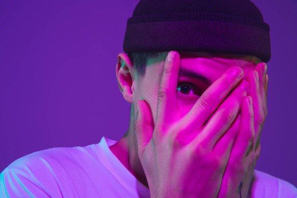 Caucasian mans portrait isolated on purple studio background in neon light - Foto, immagini