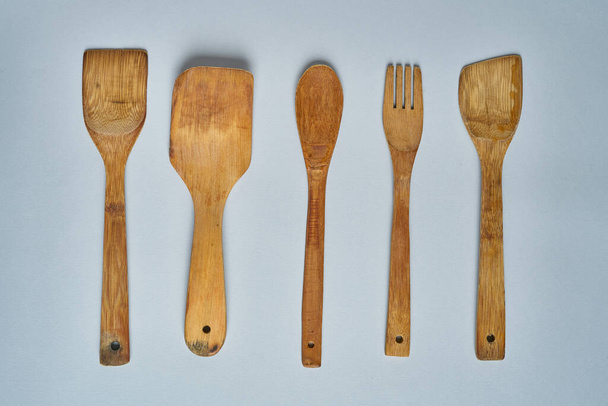 Cucharas y cucharas de madera vacías en la mesa gris. Vista superior
. - Foto, Imagen