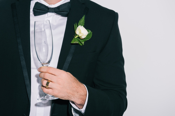vue partielle du marié tenant un verre de champagne sur fond blanc
 - Photo, image