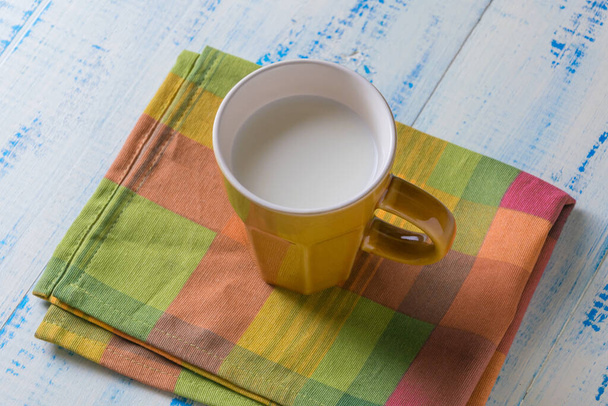 Cup with milk on a wooden background. - Photo, image