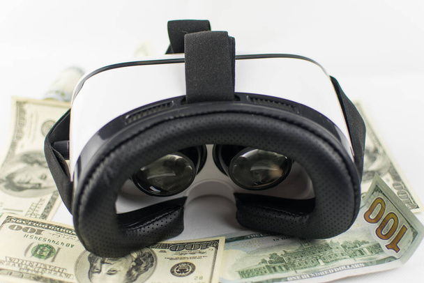 Virtual reality glasses and money on a white background. The concept of virtual money. - Photo, image