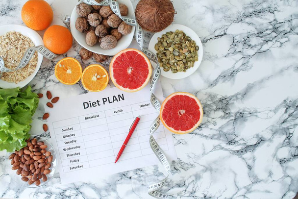 Alimentación saludable, dieta, adelgazamiento y pesaje concepto de pérdida - primer plano de papel plan de dieta con superalimentos
 - Foto, imagen