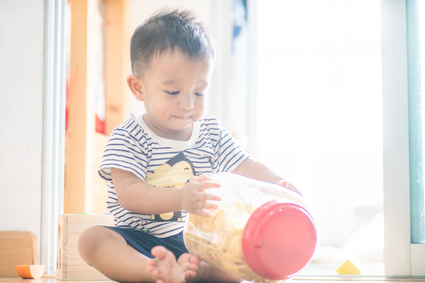 Очаровательный малыш малыша с закусками питания в доме, Смешной мальчик образования - Фото, изображение