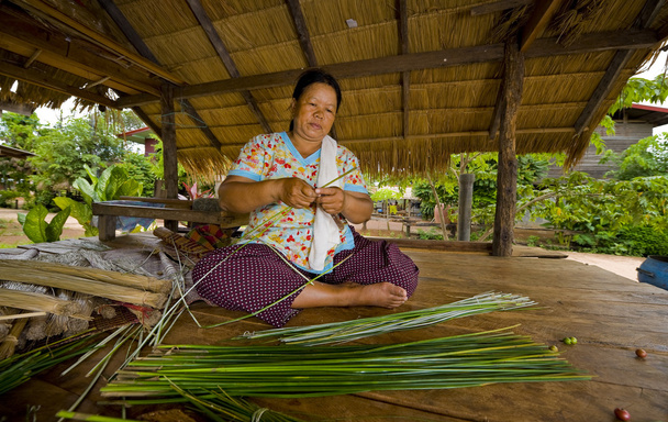 Mujer asiática haciendo esteras de paja
 - Foto, Imagen