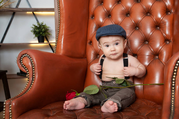 baby kleine heer zitten op een stoel met een roos gefeliciteerd - Foto, afbeelding