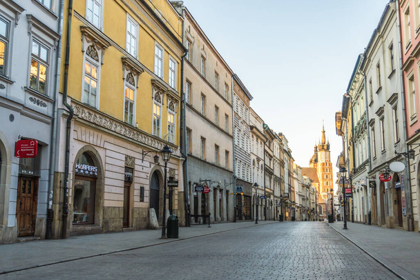 Poland, Krakow 20.04.2020: Empty, deserted streets of old city of Krakow in morning light during coronavirus pandemic. No tourists, closed restaurants and shops. Spring blue sky. Closed borders - Foto, immagini