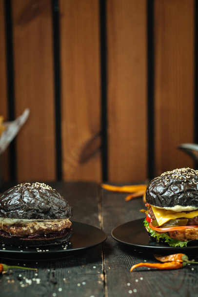 Két fekete burger sötét fa textúra háttér - Fotó, kép