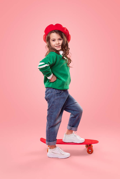 Trendy girl with skateboard smiling for camera - Foto, Imagen