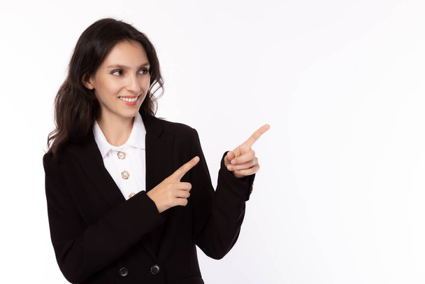 Smiling caucasian business woman pointing up and looking at copy space with satisfied, happy, smiley face.  Attractive beautiful young businesswoman wear suit, shirt. business concept white background - Photo, Image