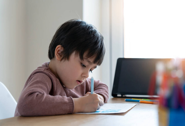 Kid self izolace pomocí tabletu pro své domácí úkoly, Dítě dělá pomocí digitálních tablet vyhledávání informací na internetu během covid 19 uzamčení, Domácí školství, Sociální vzdálenost, E-learning on-line vzdělávání - Fotografie, Obrázek