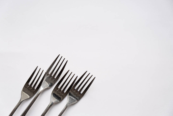 A close up of a Forks lie on a white background - Foto, afbeelding
