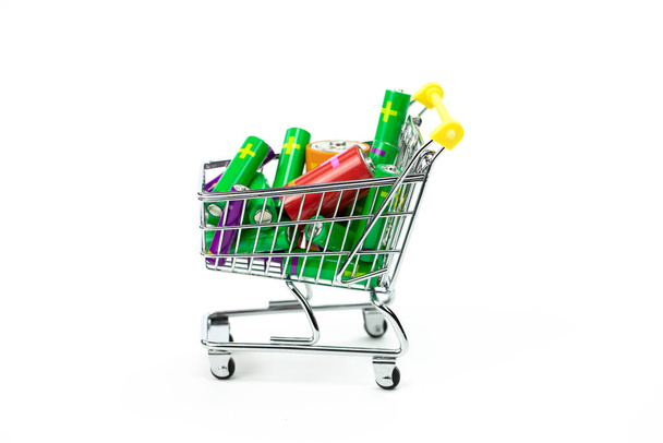 Chariot de jouets du supermarché plein de batteries colorées isolées sur blanc
 - Photo, image