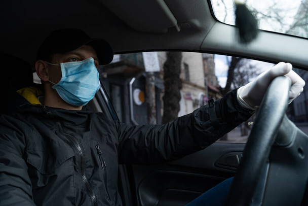 ニューヨーク、米国-エイプリル社2019年1月:男は隔離中に車内におり、保護マスクと手袋を着用して安全を確保しています。 - 写真・画像