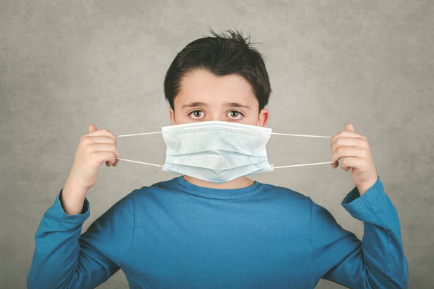 Коронавирус, ребенок в медицинской маске на сером фоне
 - Фото, изображение