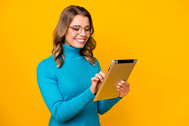 Photo of attractive business lady curly hairdo hold modern technology e-reader corporate report online email wear specs blue turtleneck isolated bright yellow color background - 写真・画像