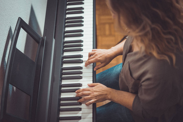 Όμορφη γυναίκα παίζει πιάνο στο σπίτι σε περιορισμένες ημέρες - Φωτογραφία, εικόνα