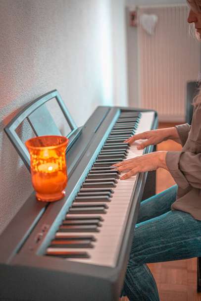 Mujer bonita tocando el piano en casa en días confinados
 - Foto, imagen