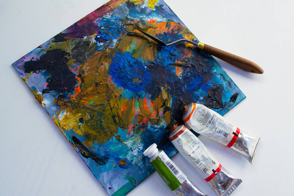 Art materials, paints and a palette knife on a white background. - Fotó, kép