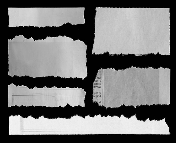 Seis pedazos de periódico roto sobre fondo negro
 - Foto, Imagen