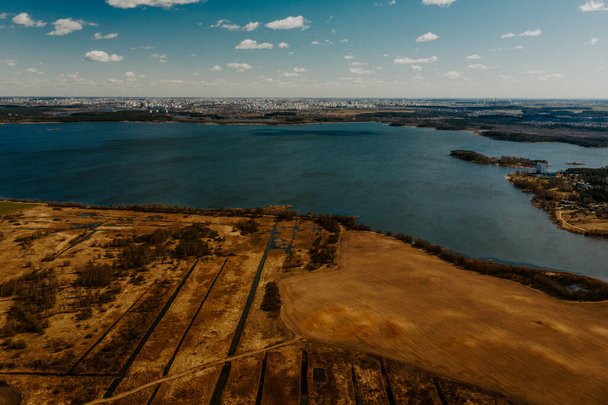 Luchtfoto van het meer van boven. Herfst of lente natuur achtergrond. Drone fotografie. Vliegen boven het herfstbos. Luchtfoto van weide en veld. Landschap met meer. Milieubescherming - Foto, afbeelding