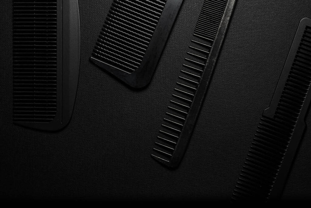 On a black surface are old barber tools. barber tools. four comb. black monochrome. frame. top view flate lay. - Foto, Bild
