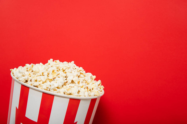 Popcorn op een rode achtergrond. Plaats voor tekst - Foto, afbeelding