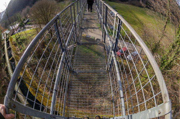 Passerelle du pont suspendu vue d'en haut au premier plan
 - Photo, image