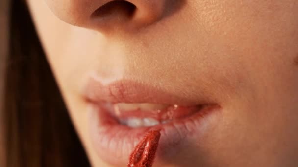 seksikäs huulet tyttö huulipunaa. Kaunis nuori nainen maalaamassa punaista huulipunaa huulilleen. Nuori nainen soveltamalla hänen meikki
 - Materiaali, video