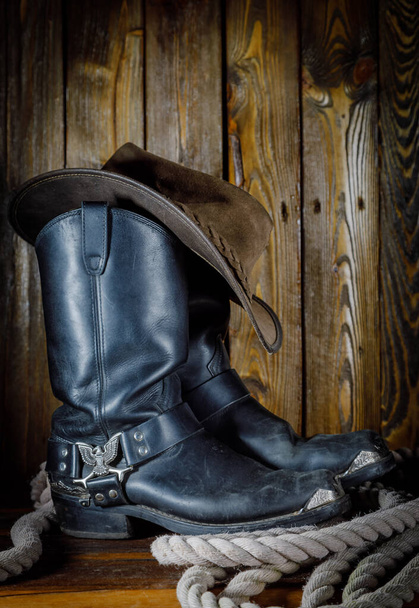 chapéu de cowboy, botas e corda no fundo de madeira
 - Foto, Imagem