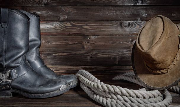 kapelusz kowbojski, buty i lina na drewnianym tle - Zdjęcie, obraz