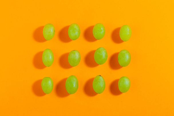 Set of fresh grapes isolated on orange background, top view, concept photo. - Foto, imagen