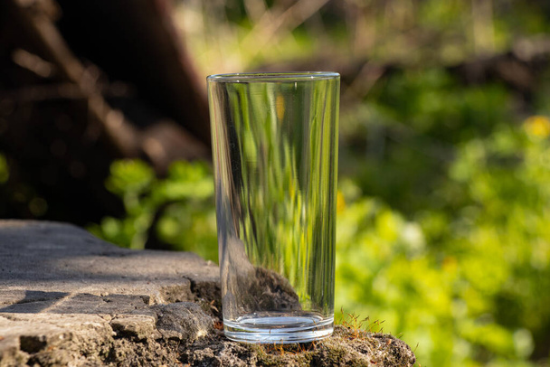 an empty transparent glass goblet stands on the ground - Φωτογραφία, εικόνα