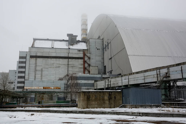 Neue sichere Ummantelung über den Überresten von Reaktor 4 und dem alten Sarkophag im Kernkraftwerk Tschernobyl. Dezember 2016 - Foto, Bild