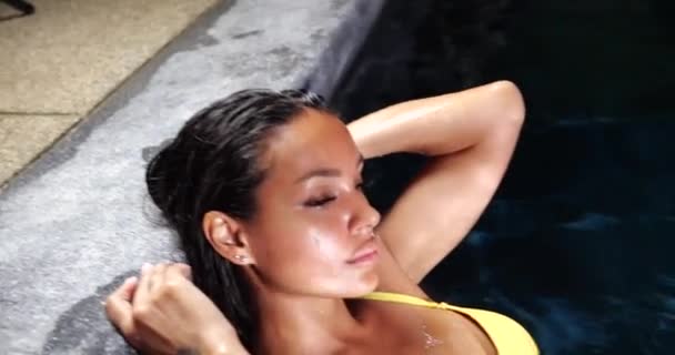 Mulher sexy na piscina à noite usando biquíni amarelo - Filmagem, Vídeo