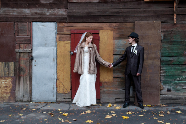 Bride and a groom standing near the building - Zdjęcie, obraz