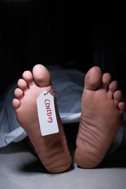 Δύο πόδια ενός νεκρού σώματος με μια ετικέτα που συνδέεται με το δάχτυλο του ποδιού - Φωτογραφία, εικόνα