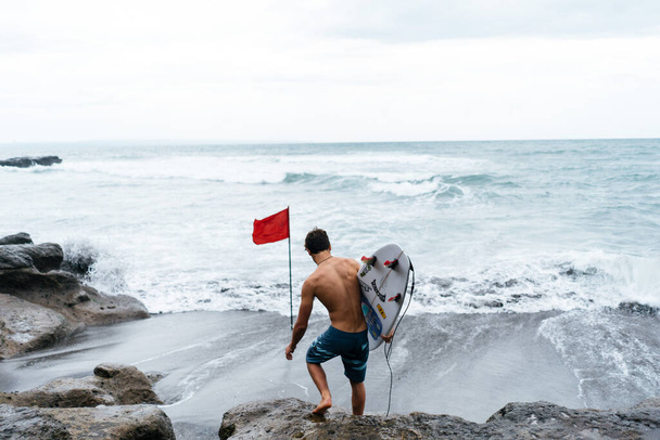 Surfer enters the ocean - Foto, afbeelding