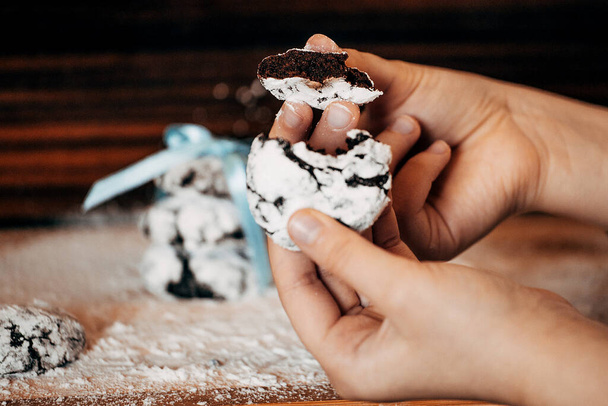 biscuits aux pépites de chocolat en sucre glace attachés avec un ruban bleu tenant une fille dans ses mains. veut manger de délicieux biscuits. bonbons dans la cuisine. bonbons dans la cuisine
 - Photo, image