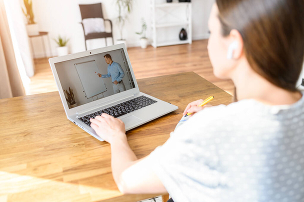 A young woman watching online classes at home - Foto, Bild