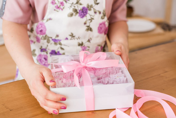 Großpackung hausgemachter Marshmallows. Frauenhände mit einer Marshmallow-Geschenkbox. - Foto, Bild