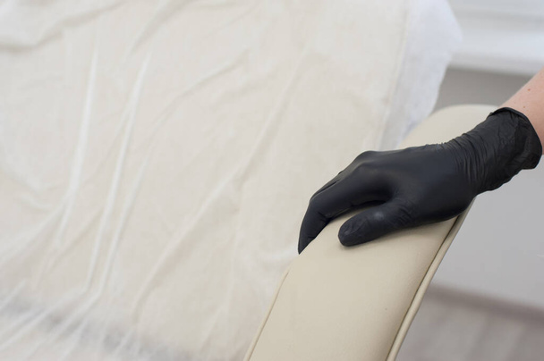Mãos de perto, mão enluvada no sofá médico
 - Foto, Imagem