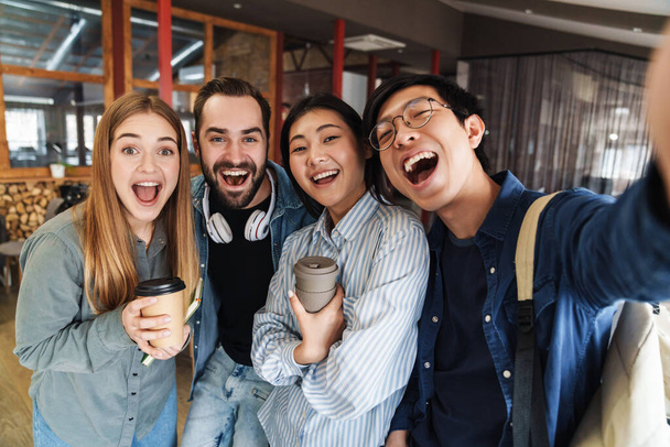 Photo of multinational cheerful students laughing while taking selfie photo in classroom - Fotoğraf, Görsel