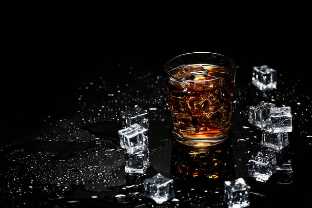 Whisky con cubetti di ghiaccio su sfondo nero dall'alto. Bicchiere di scotch e cubetti di ghiaccio su sfondo nero
 - Foto, immagini