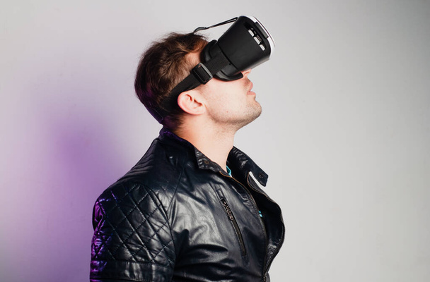 Человек в очках виртуальной реальности на белом фоне смотрит вверх
 - Фото, изображение