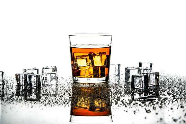 ウイスキーとアイスキューブのガラス。ウイスキーの孤立したショット。白い背景にスコッチとアイスキューブのガラス. - 写真・画像